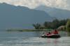 Graues Schlauchboot mit zwei Kids und roten Rettungswesten auf dem Ticino