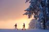 Zwei Schneeschuhwanderer im orangen Abendlicht/Sonnenuntergang