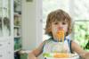 Einem Jungen hängen Spaghetti aus dem Mund