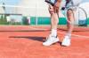 Tennisspieler hält sich Knie