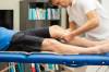 Physiotherapeut behandelt Patienten auf einer Liege