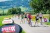 Slow Up Fahrradfahrer und Inline Skater auf einem Weg im Grünen